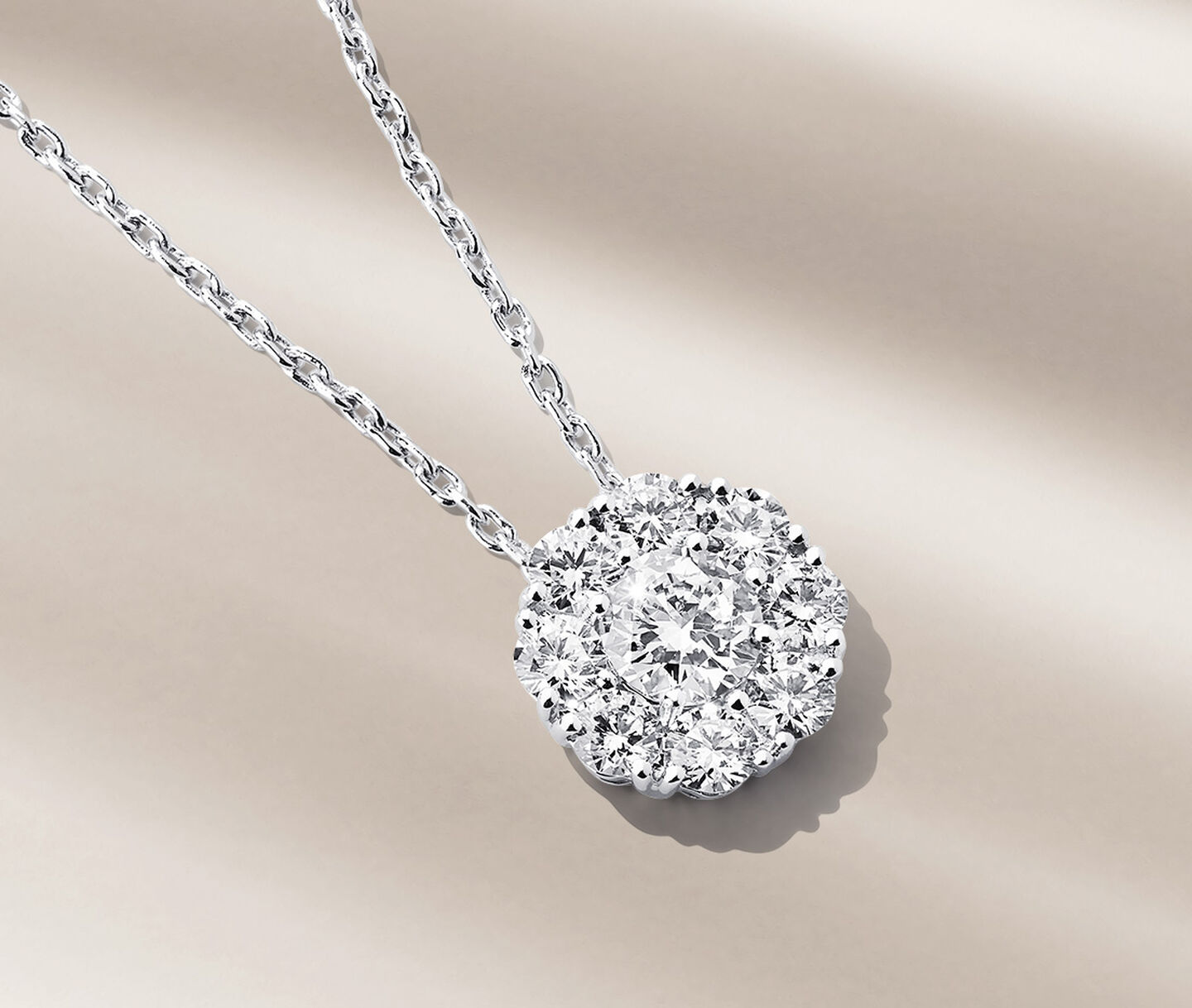 Collier avec diamants Birks Snowflake sur un fond beige.