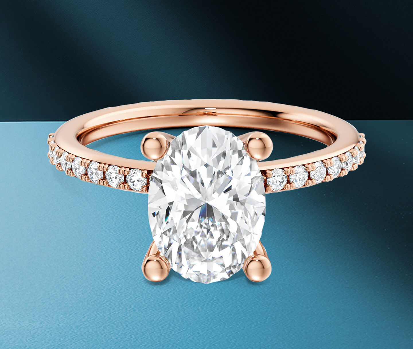 Birks Ros&eacute;e du Matin oval-cut diamond engagement ring in rose gold on a blue background.