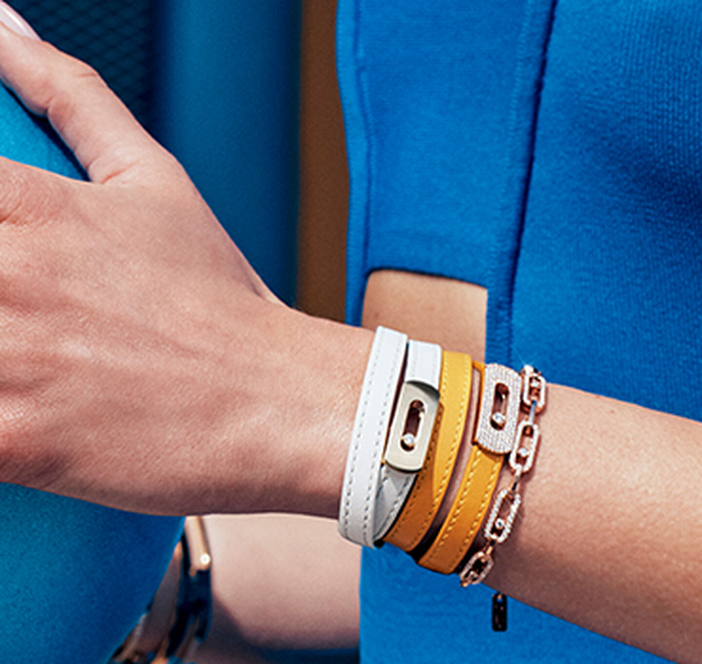Stacked white, rose, and yellow gold Messika bracelets