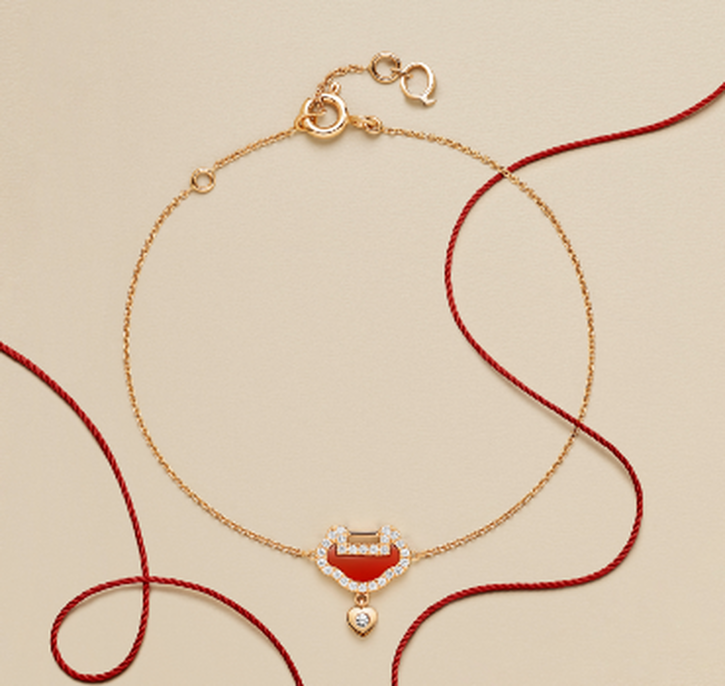 A Qeelin Yu Yi rose gold, red agate and diamond bracelet on a beige background.