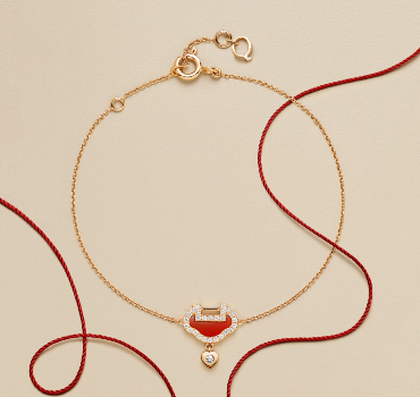 Bracelet Yu Yi par Qeelin en or rose, agate rouge et diamants sur un fond beige.