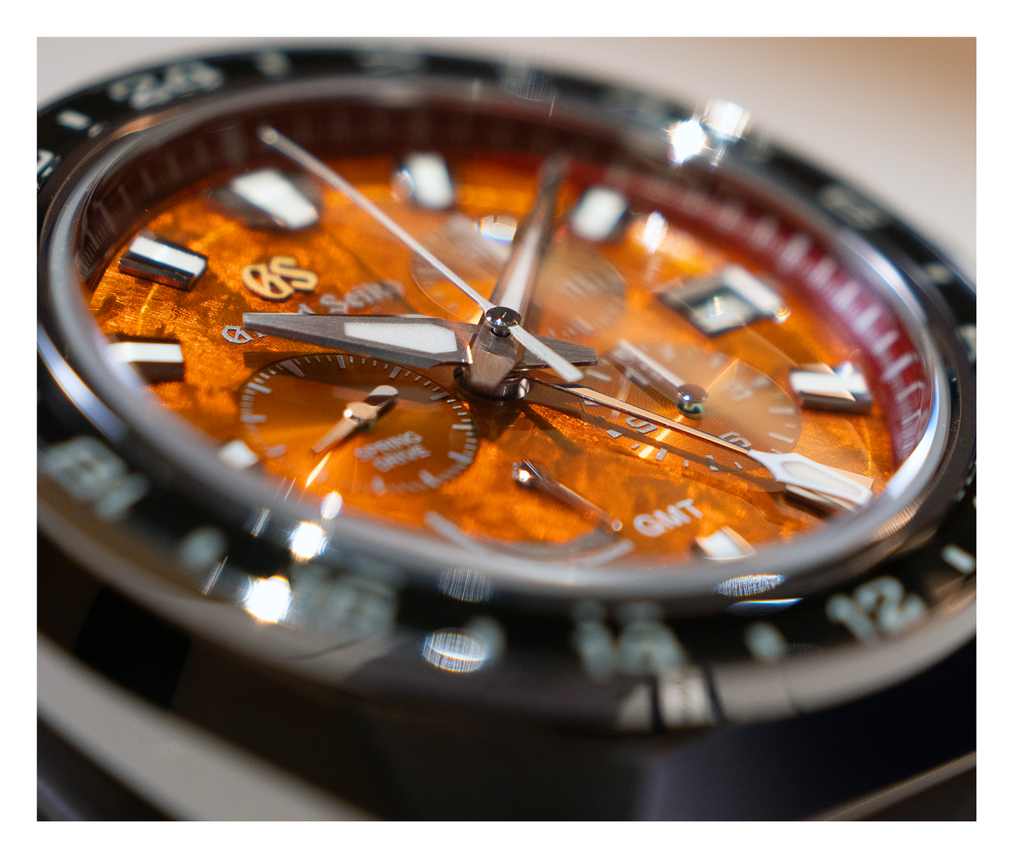 Closeup of a Grand Seiko watch with an orange dial.