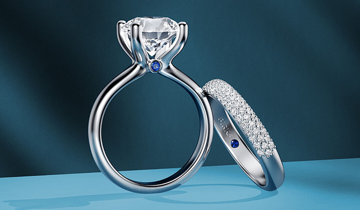 Birks Blue engagement ring and wedding band on a blue background.