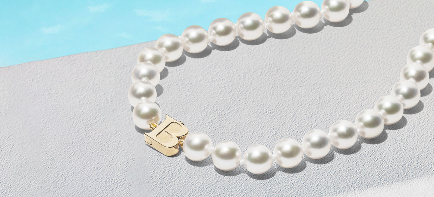 Birks Pearls Akoya necklace on a blue background.