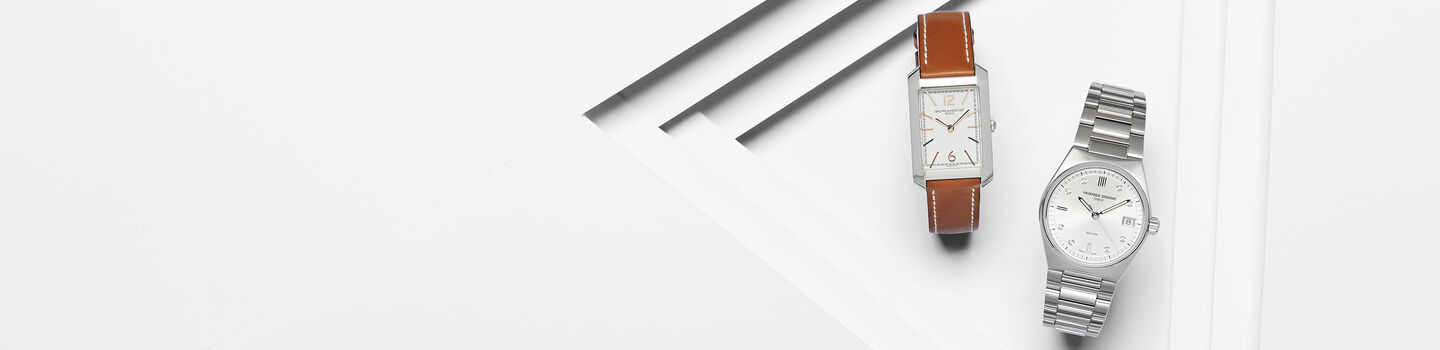 Une montre Hamptons de Baume & Mercier et Frederique Constant sur un fond blanc.