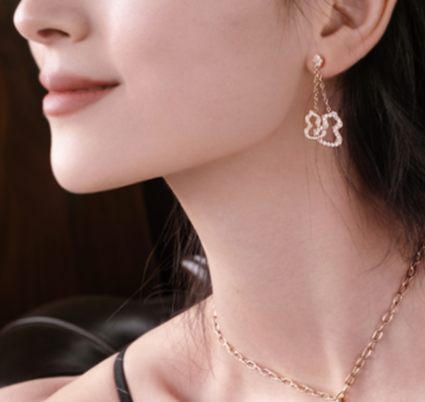 Boucles d'oreilles pendentives Wulu de Qeelin en or rose et diamants sur une mannequin.