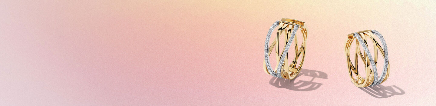 Boucles d'oreilles en or jaune et diamants Birks Rosée du Matin sur un fond rose et jaune