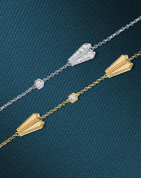 Birks Beekeeper diamond and gold bracelets on a blue background.