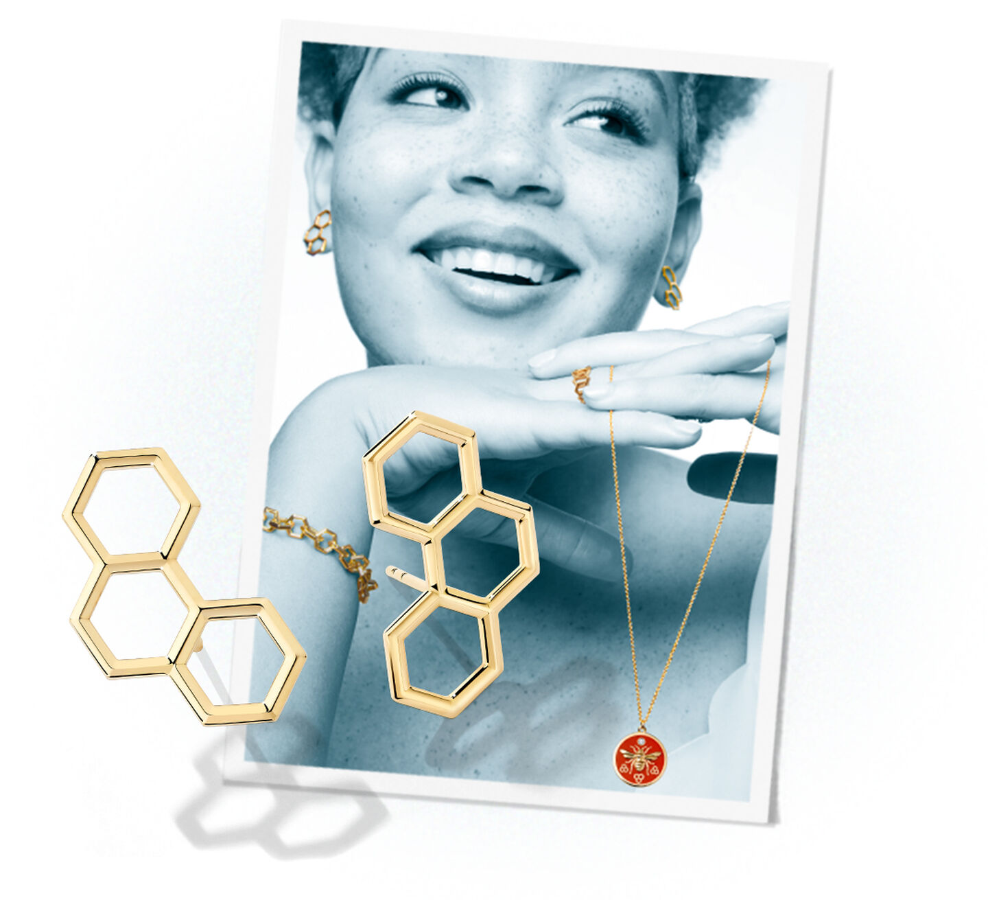 Gold hexagonal drop earrings on a photograph of a smiling model