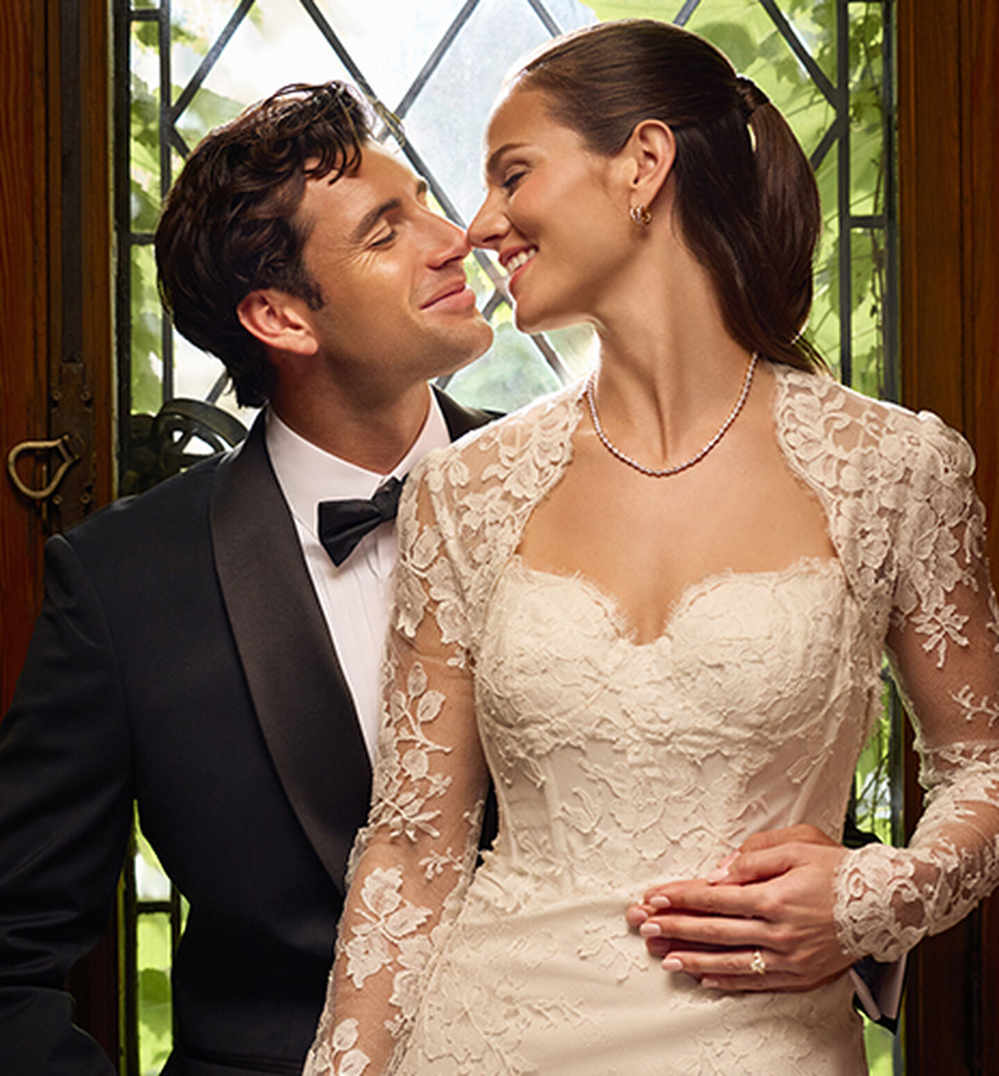 A couple wearing Birks Bridal jewellery, including an engagement ring and diamond jewellery.