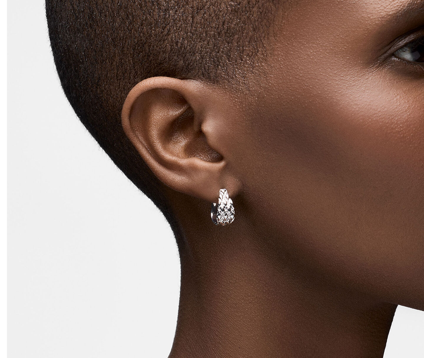 A woman wearing Birks Essentials silver hoop earrings.