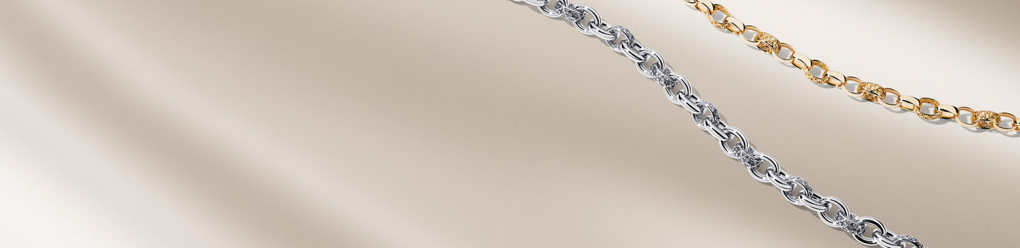 Birks Dare to Dream chain necklaces on a beige background.