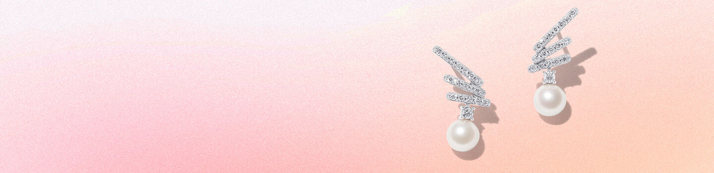 Boucles d'oreilles en perles de Yoko London sur un fond rose et beige.