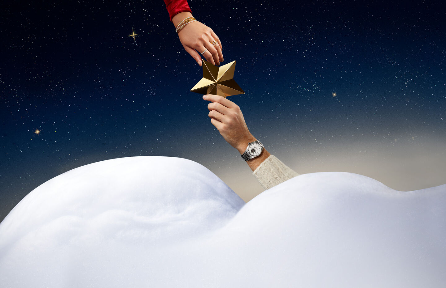 A man and woman's hand hold a Birks Blue Box wearing jewellery from Maison Birks with a starlight background.