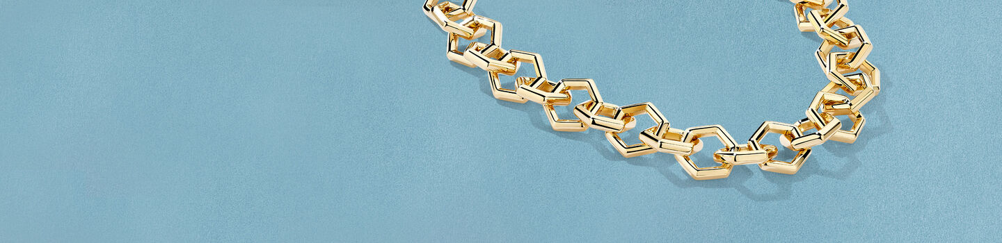 Birks Beekeeper yellow gold bangle bracelet on a sky bracelet.