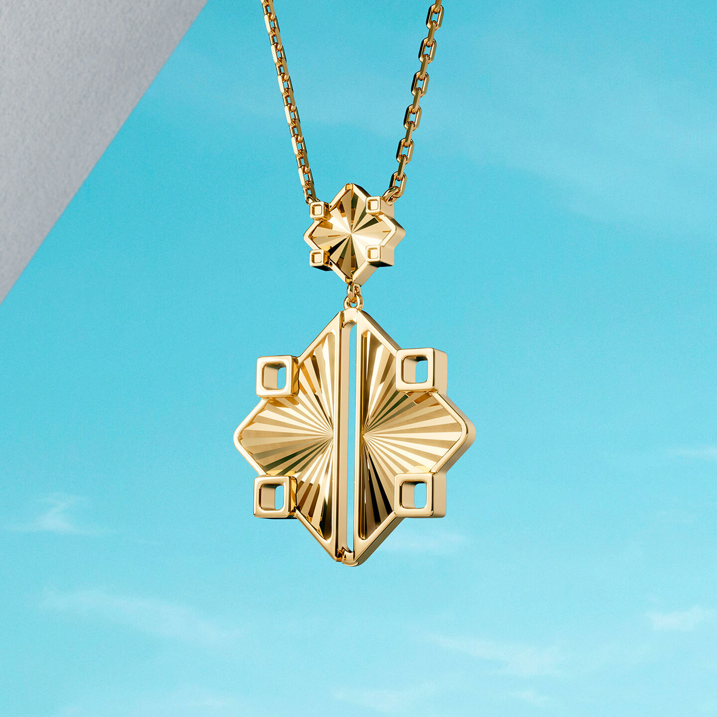 Collier Birks Muse en or jaune sur un fond bleu.