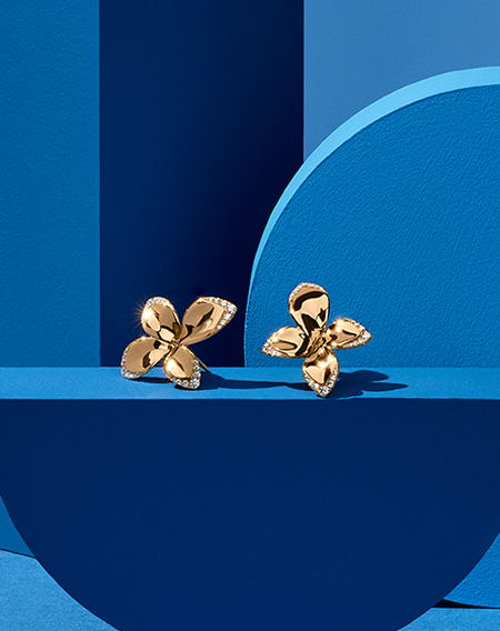 Pasquale Bruni Giardini Segreti earrings on a blue background.