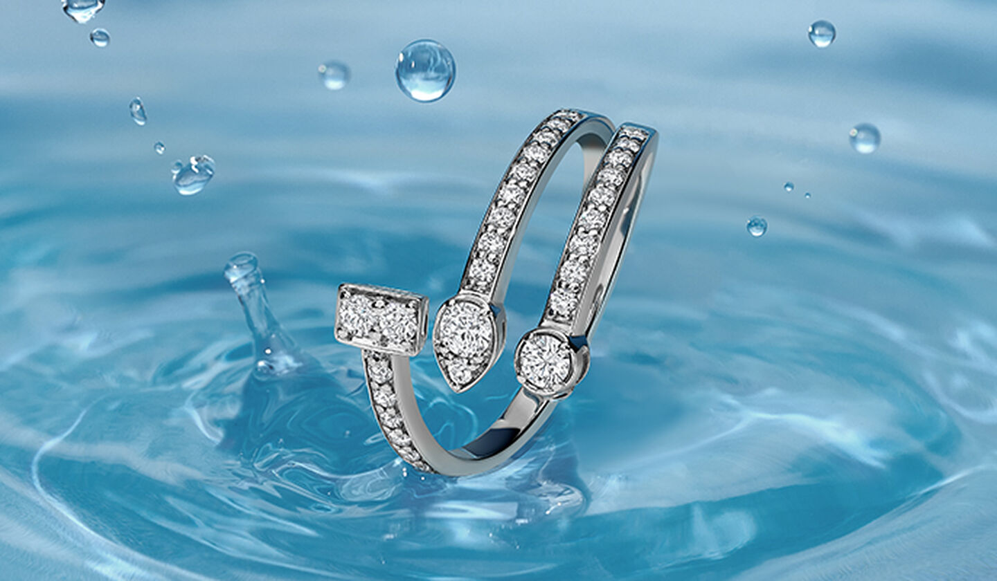 Bague Birks Splash en or blanc à 3 rangs de diamants sur fond bleu avec goutte d'eau.