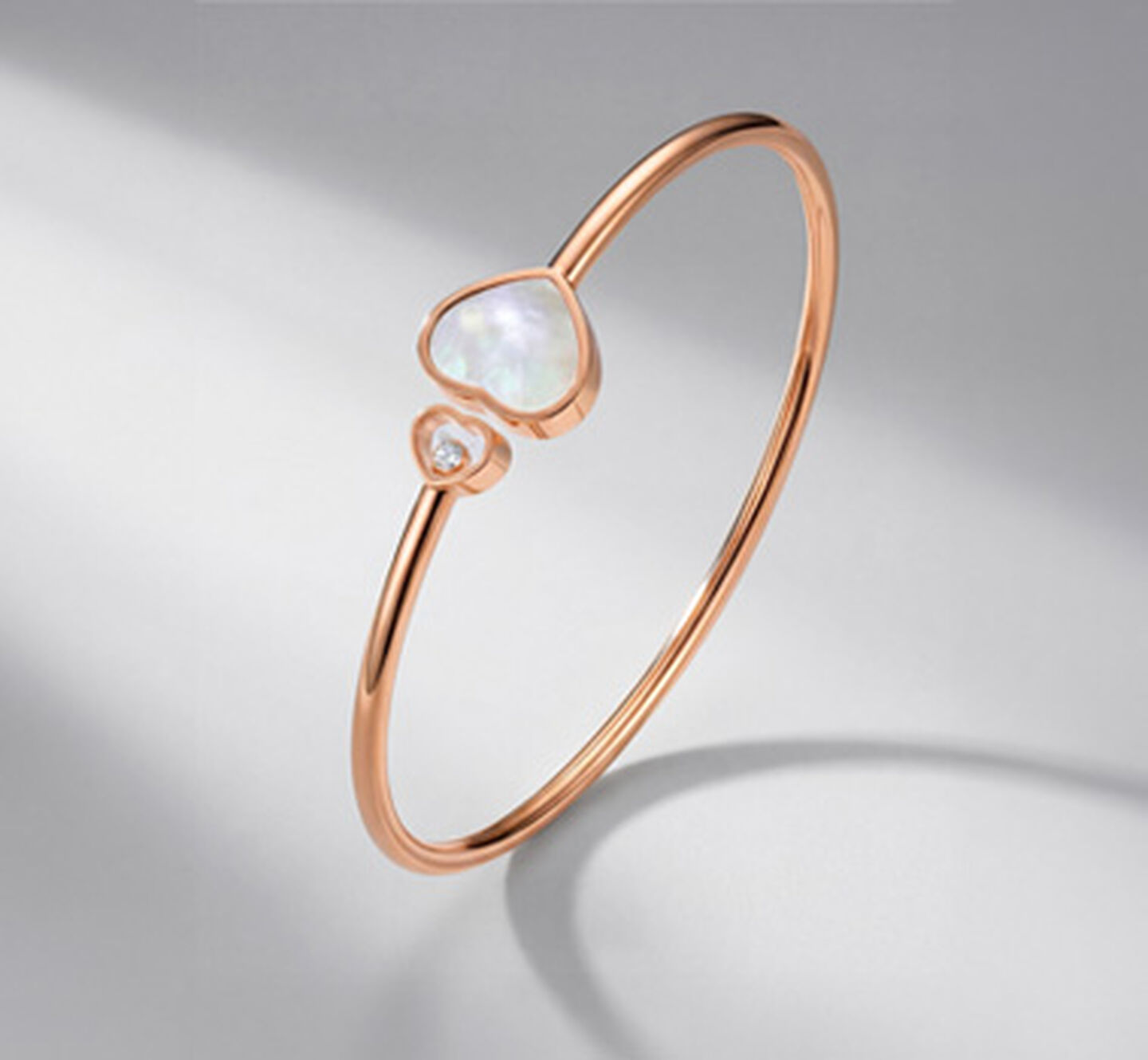 Chopard Happy Hearts rose gold bracelet on a grey background.