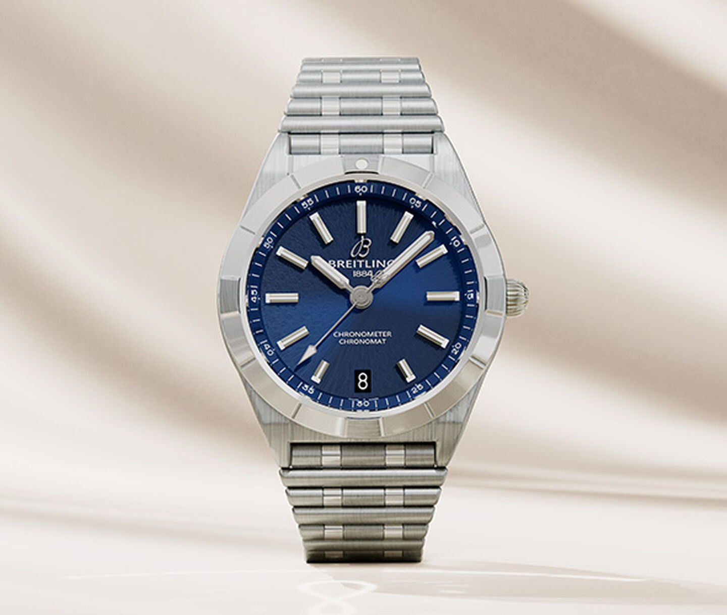 Breitling Chronomat with blue dial watch on a satin beige background.