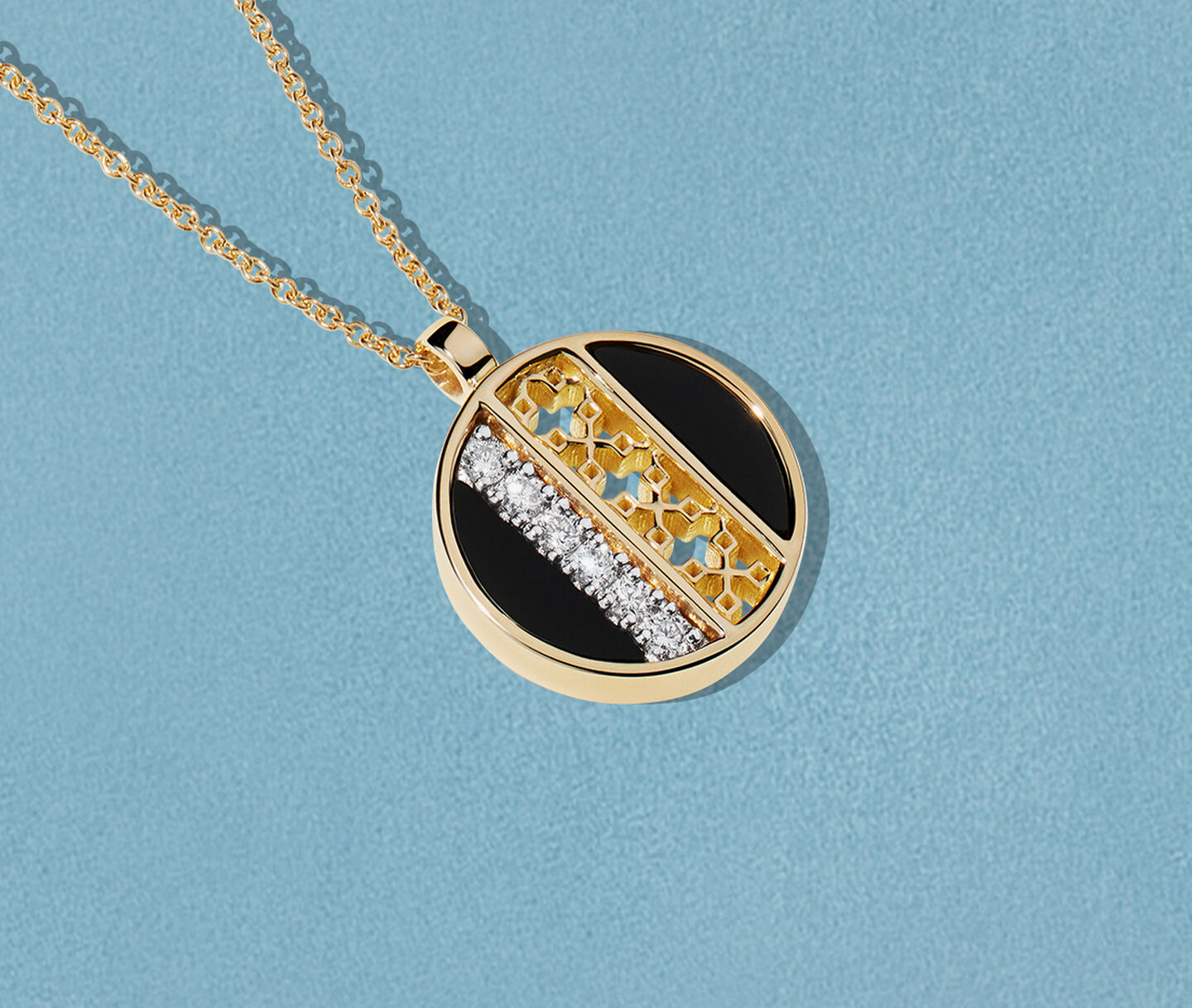 Collier Birks Dare to Dream avec onyx en or jaune sur un fond bleu.
