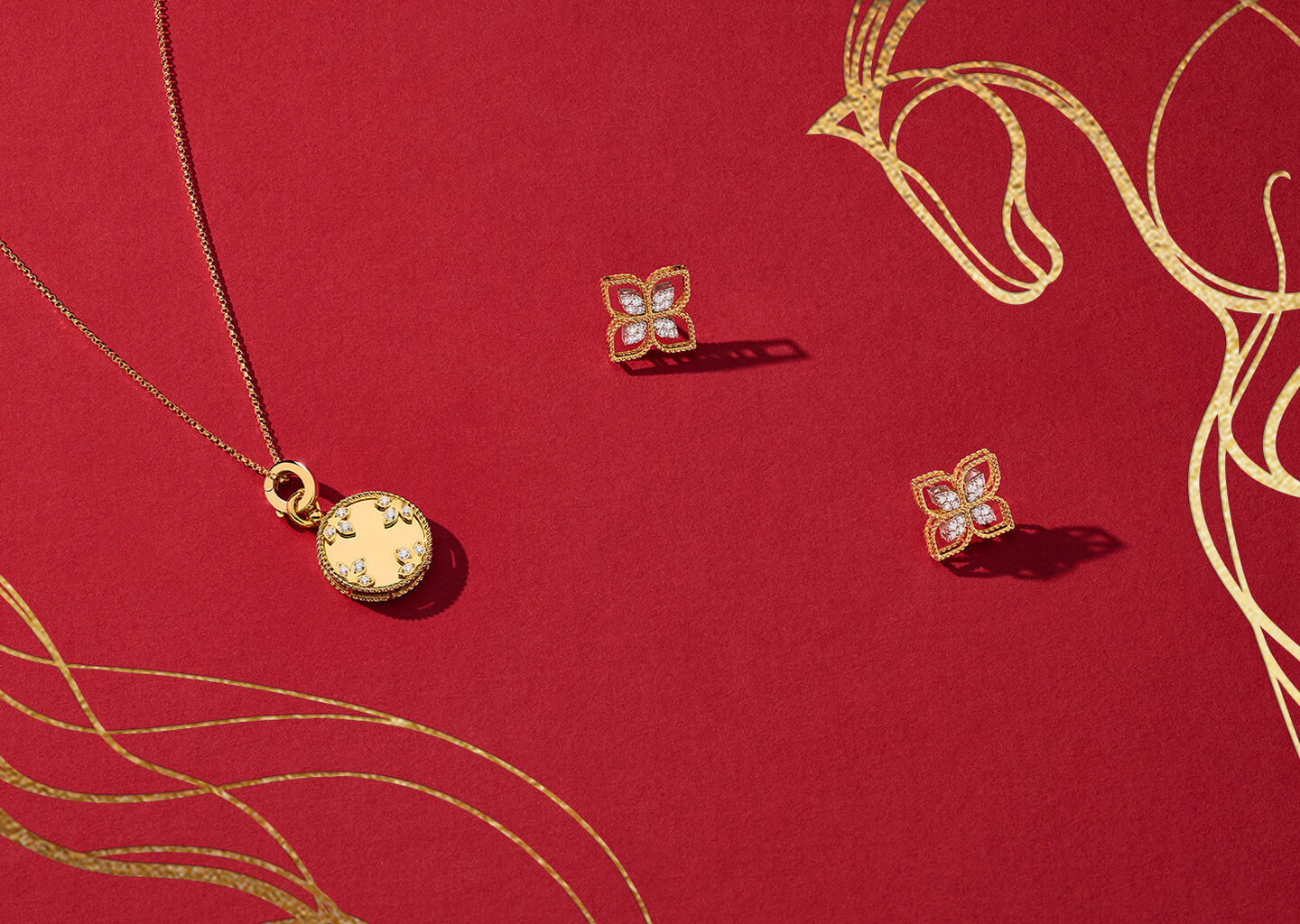 Yellow gold Roberto Coin jewellery on a red background.