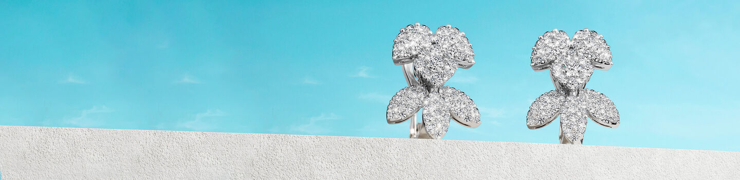 Boucles d'oreilles Birks Snowflake sur un fond bleu.
