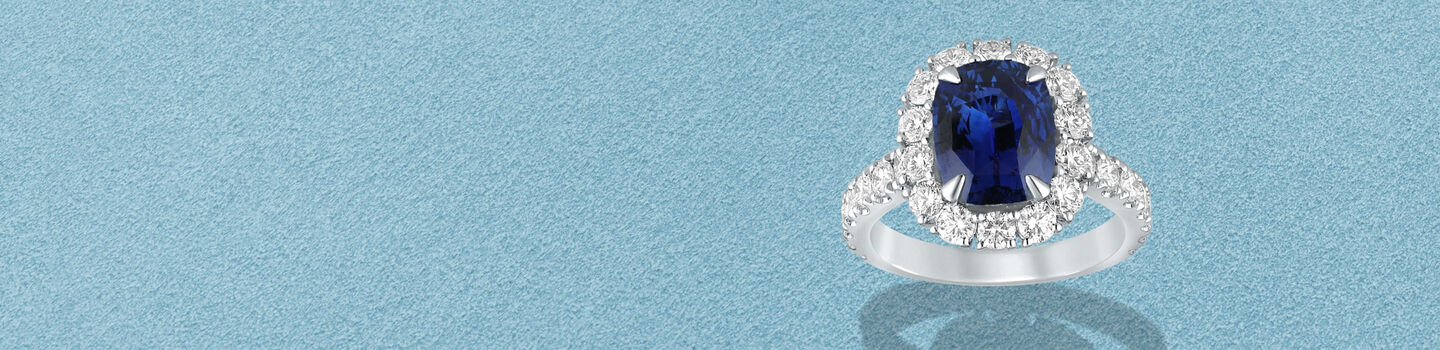 Birks Pure Desire sapphire and diamond ring on a blue background.
