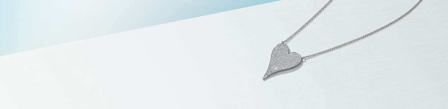 Collier en or blanc avec diamants de Shy Creation sur un fond bleu.