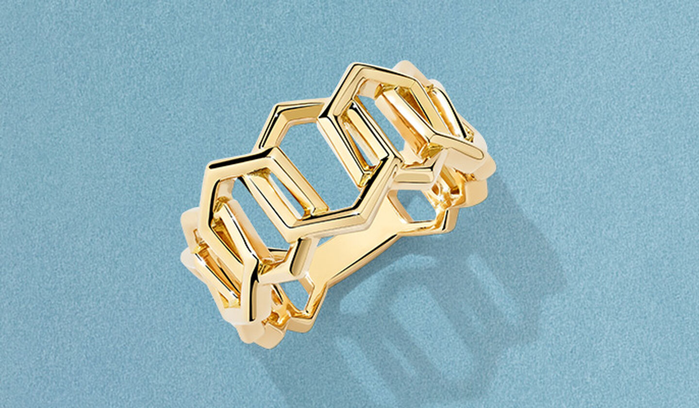 Birks Bee Chic yellow gold ring on a blue background.