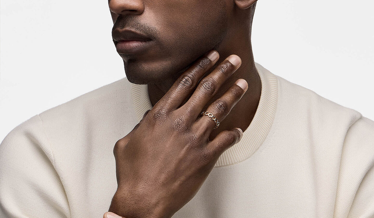 A man wearing a Birks Iconic Bee Chic silver stackable ring.