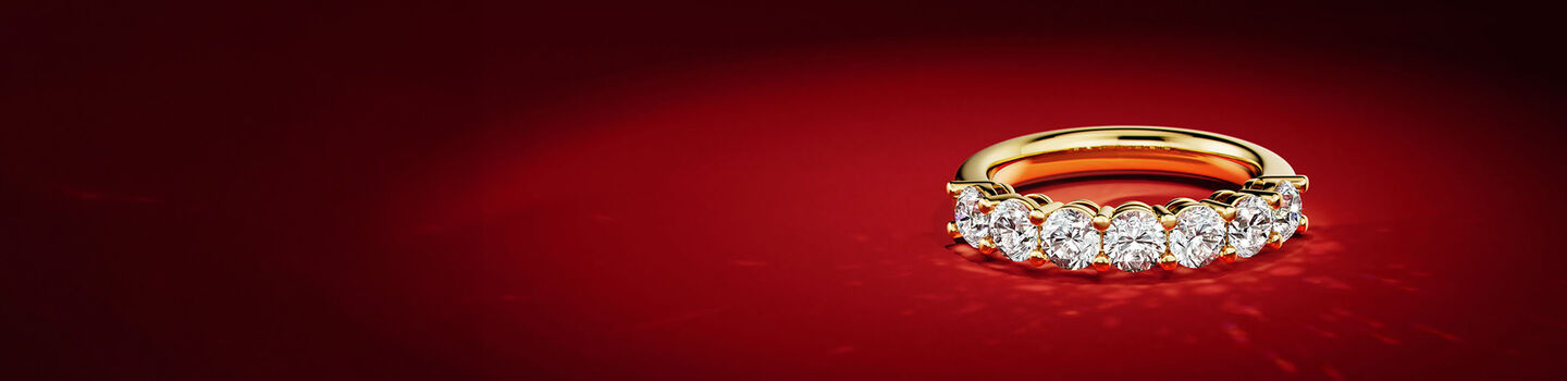 Maison Birks yellow gold and diamond ring on a red background.
