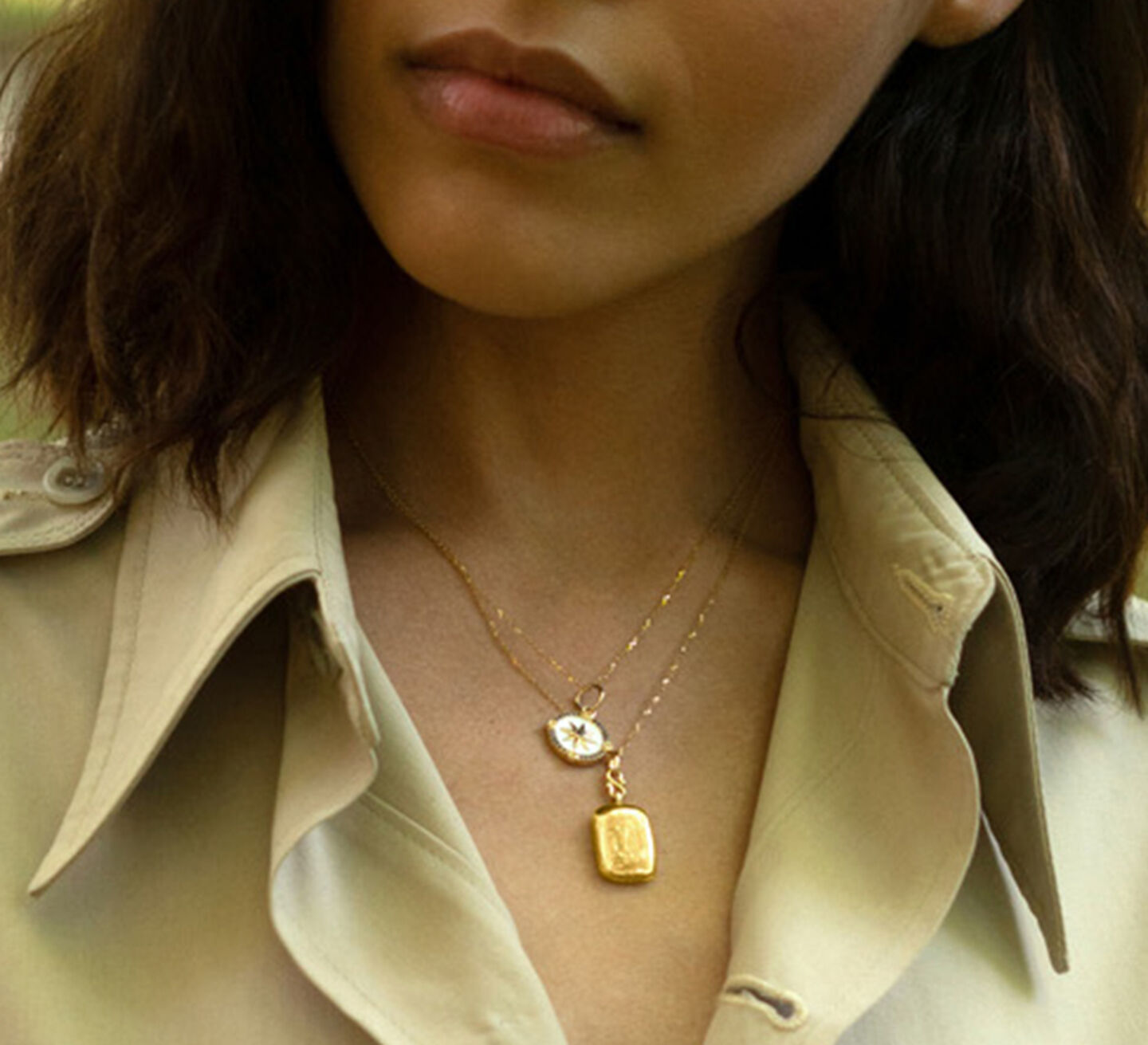 model wearing a gold and a silver locket