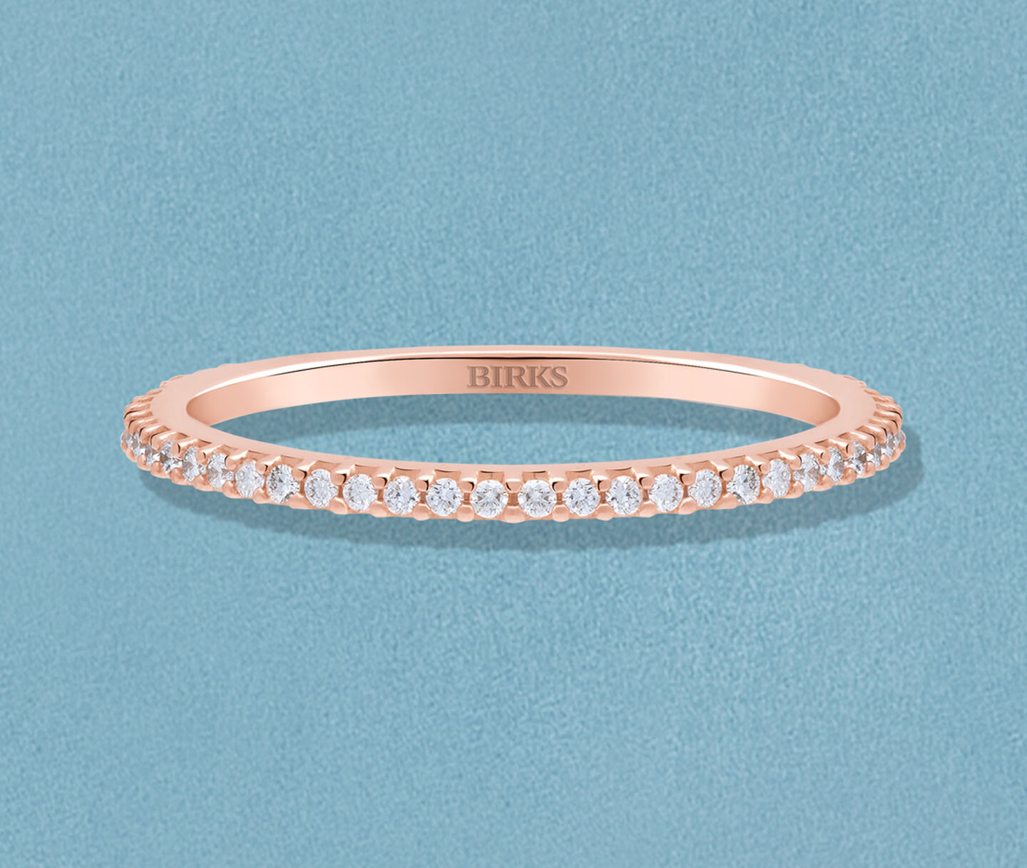 Collier Birks Iconic Bee Chic en argent sur fond bleu.