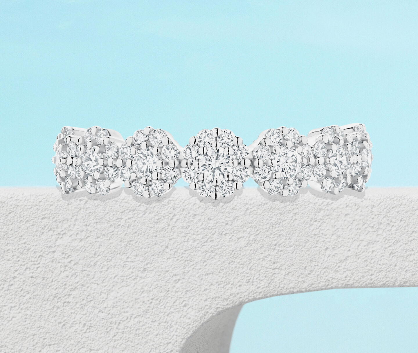 Birks Iconic Snowflake diamond ring on a blue background.