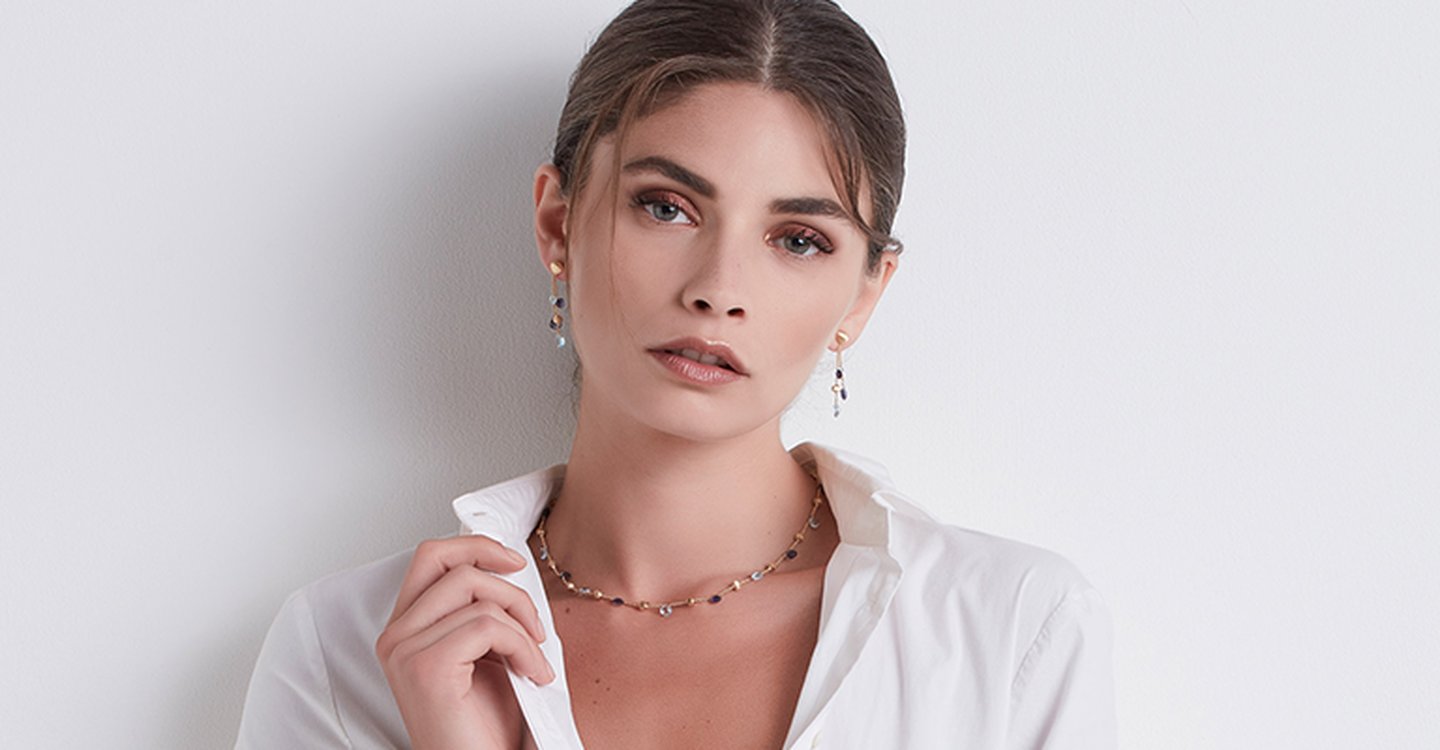 Femme portant un collier et des boucles d'oreilles Marco Bicego.