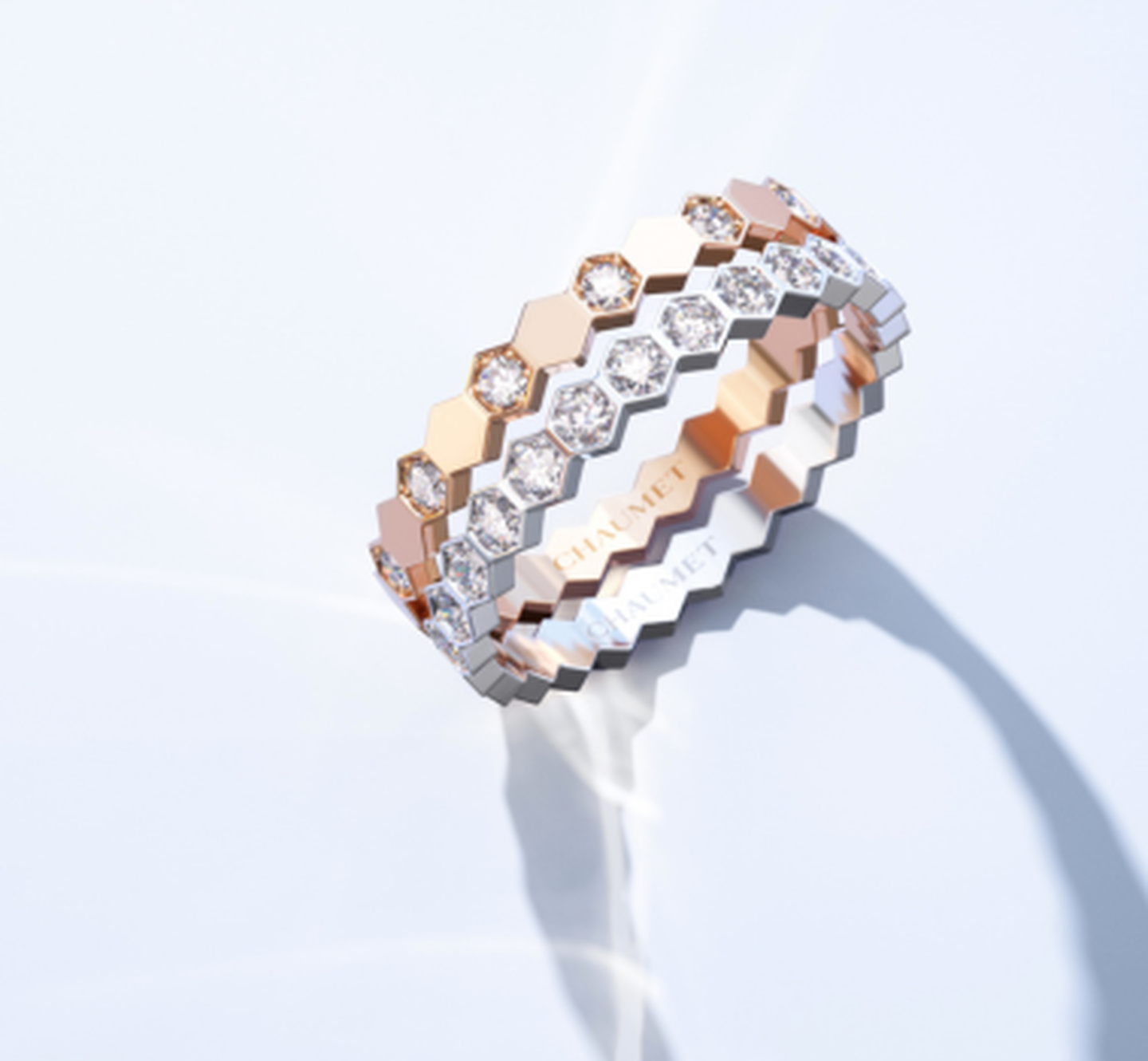A stack of Chaumet Bee My Love rings on a white-grey background.