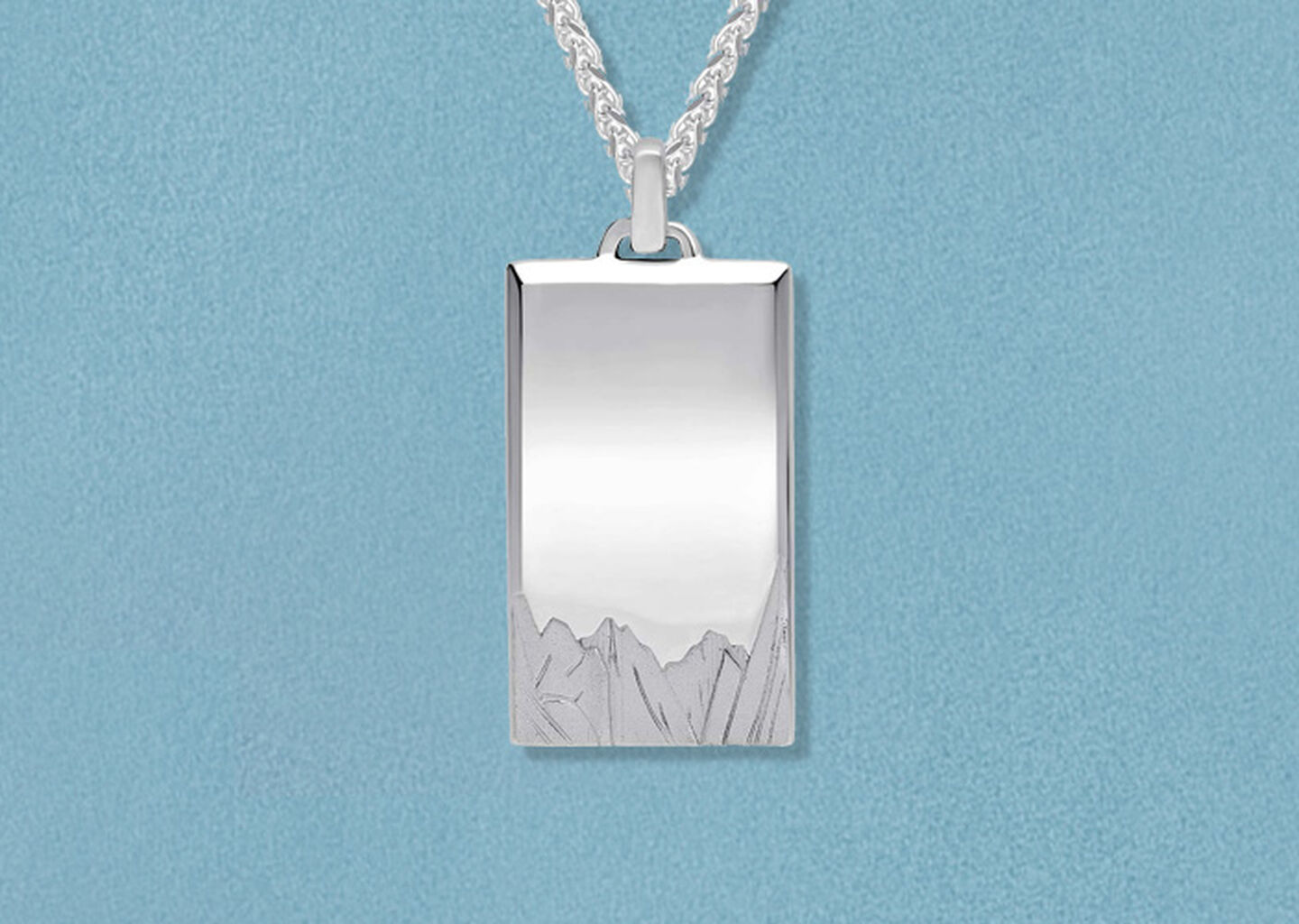 Birks men's silver necklace on a blue background.