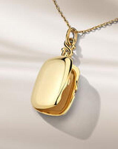 Monica Rich Kosann yellow gold necklace on a beige background.