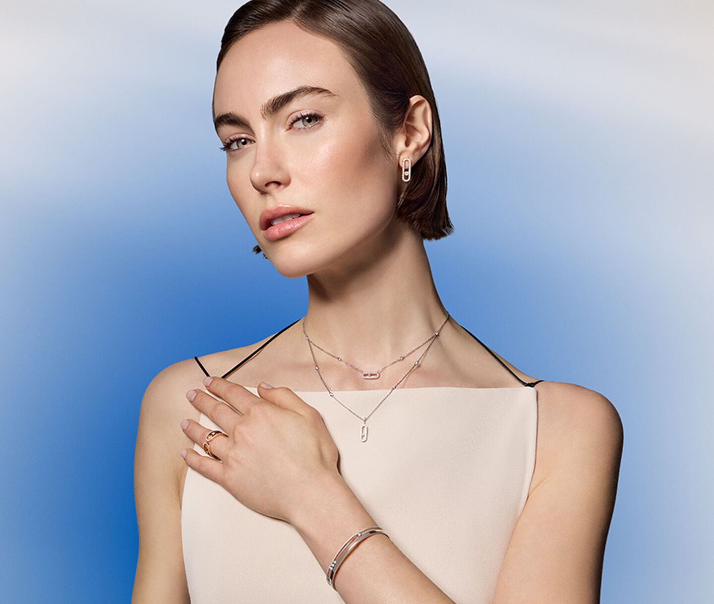 A woman wearing diamond jewellery from Maison Birks on a blue background.