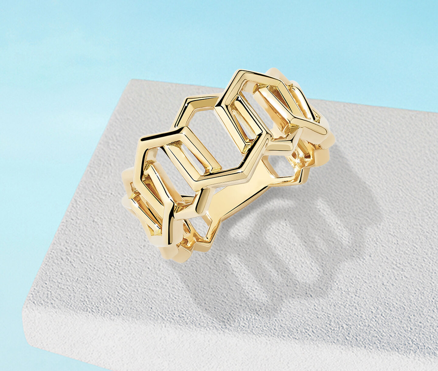 Birks Bee Chic yellow gold ring on a blue background.