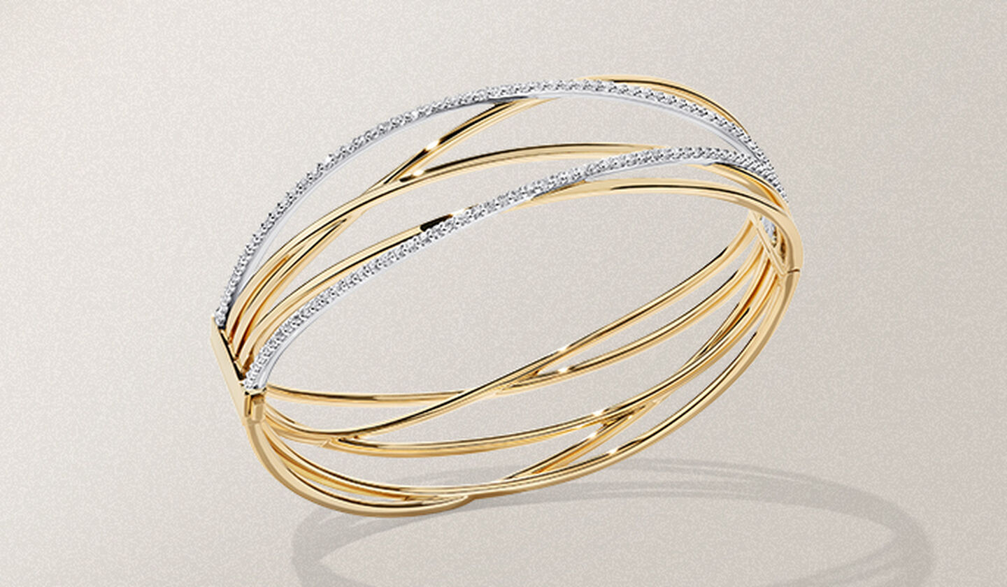 Un bracelet en or jaune et diamants de la collection Birks Rosée du Matin sur un fond beige.