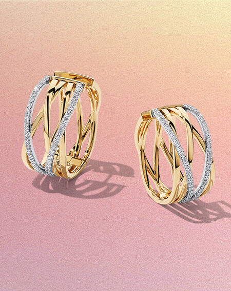 Boucles d'oreilles en or jaune et diamants Birks Rosée du Matin sur un fond rose et jaune