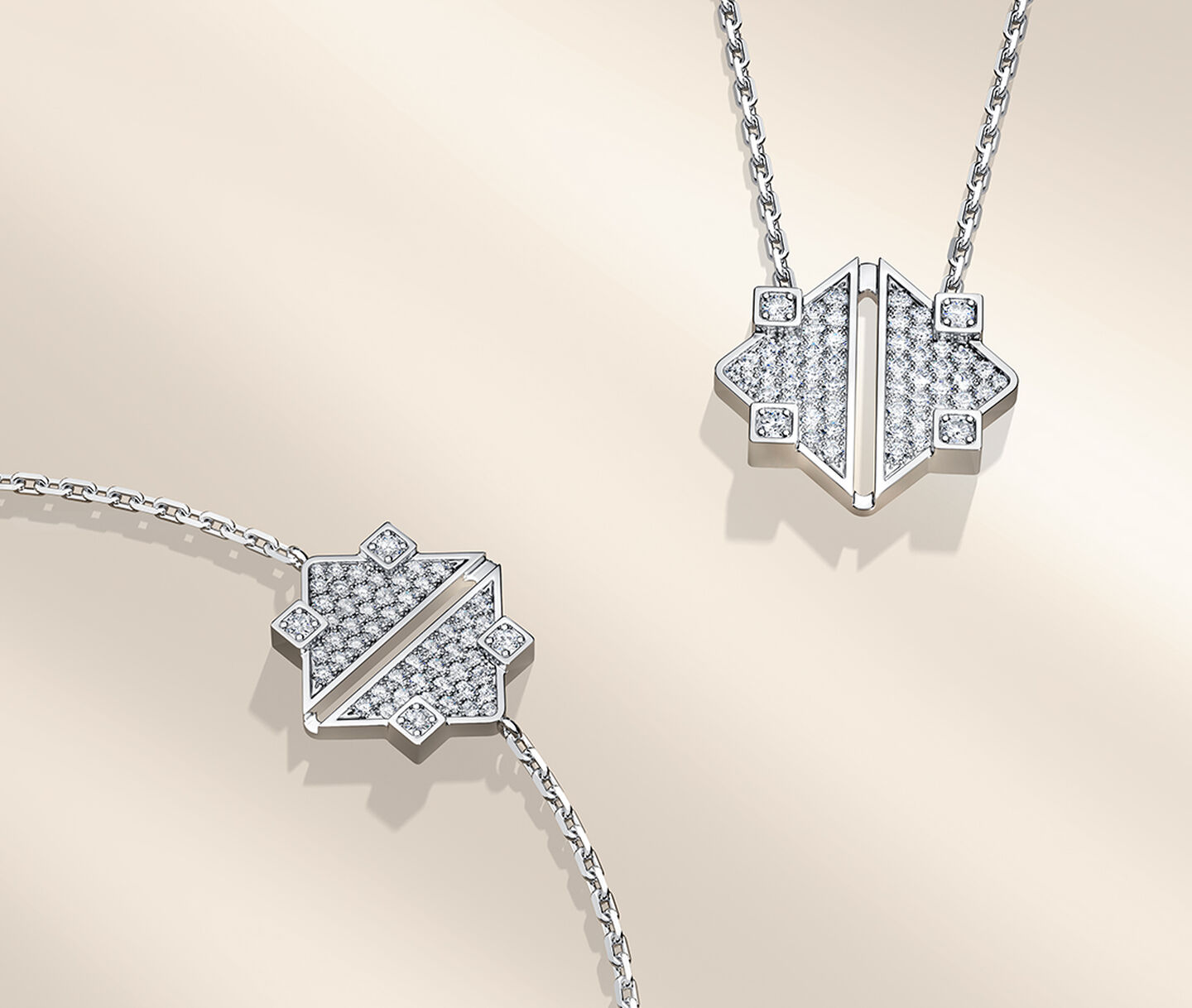 Birks Dare to Dream white gold and diamond pendant and bracelet on a beige background.