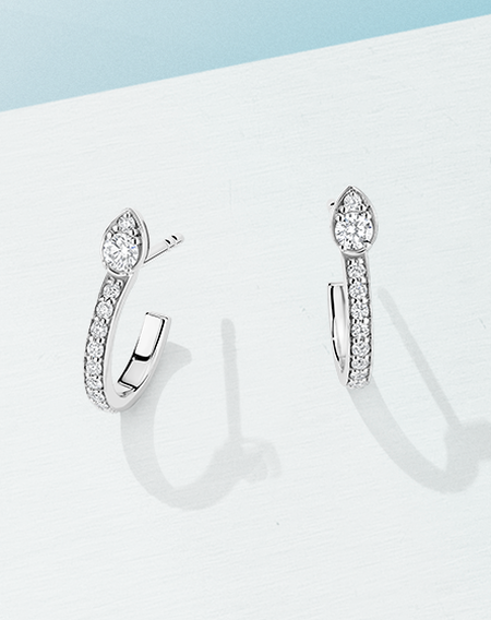 Boucles d'oreilles Birks Splash sur un fond bleu.