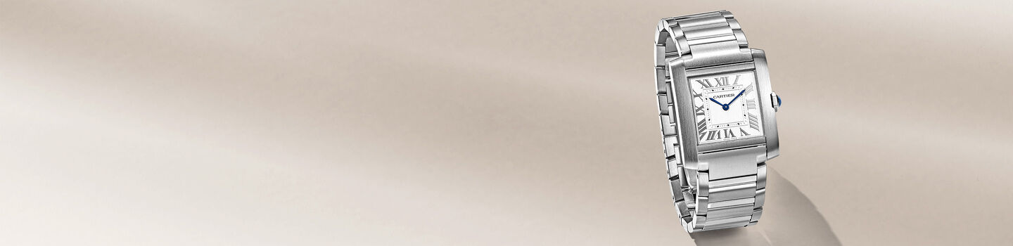 Tank de Cartier men's watch on a beige background.
