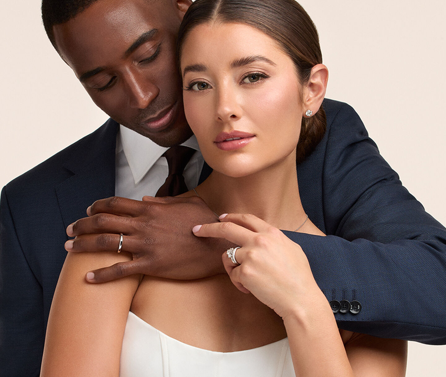 A couple embracing on their wedding day wearing Birks Bridal jewellery.