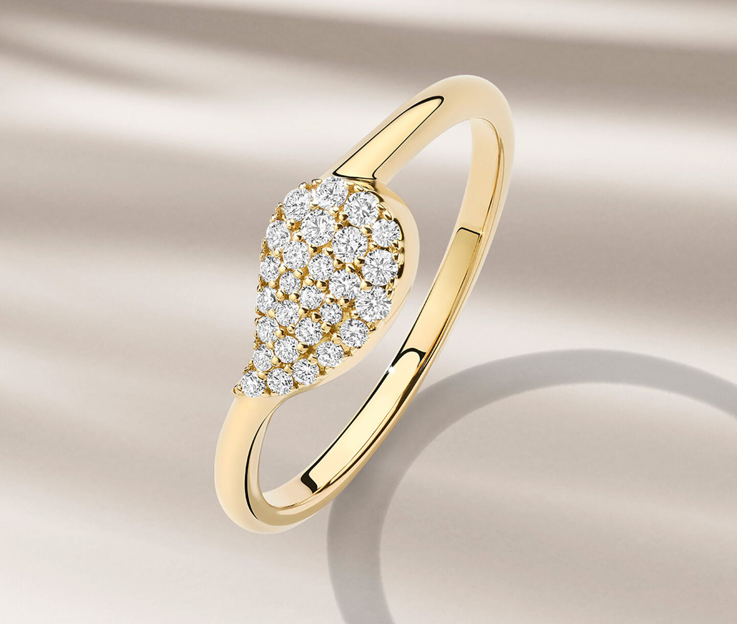 Birks Petale diamond and yellow gold ring on a beige background.