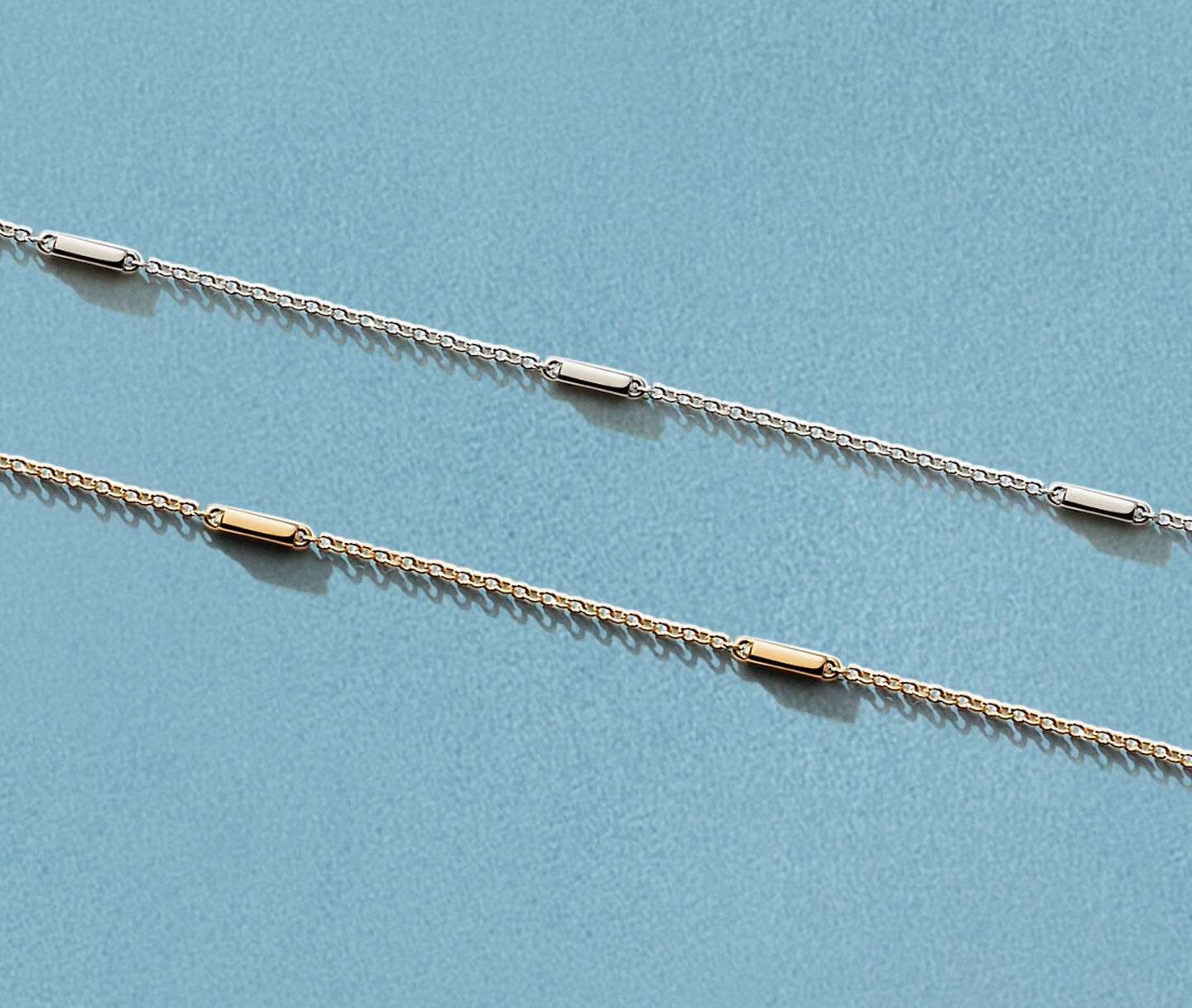 Bijoux Birks Iconic Ros&eacute;e du Matin en or et argent sur fond bleu. 