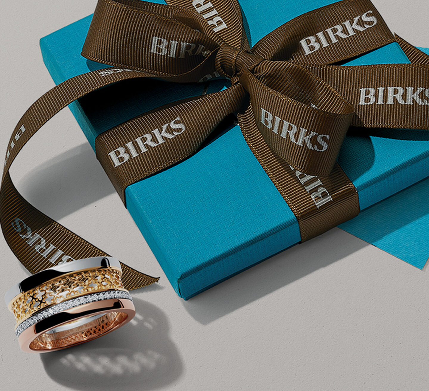 Maison Birks Signature Blue Box wrapped in brown ribbon and Birks Dare to Dream Ring